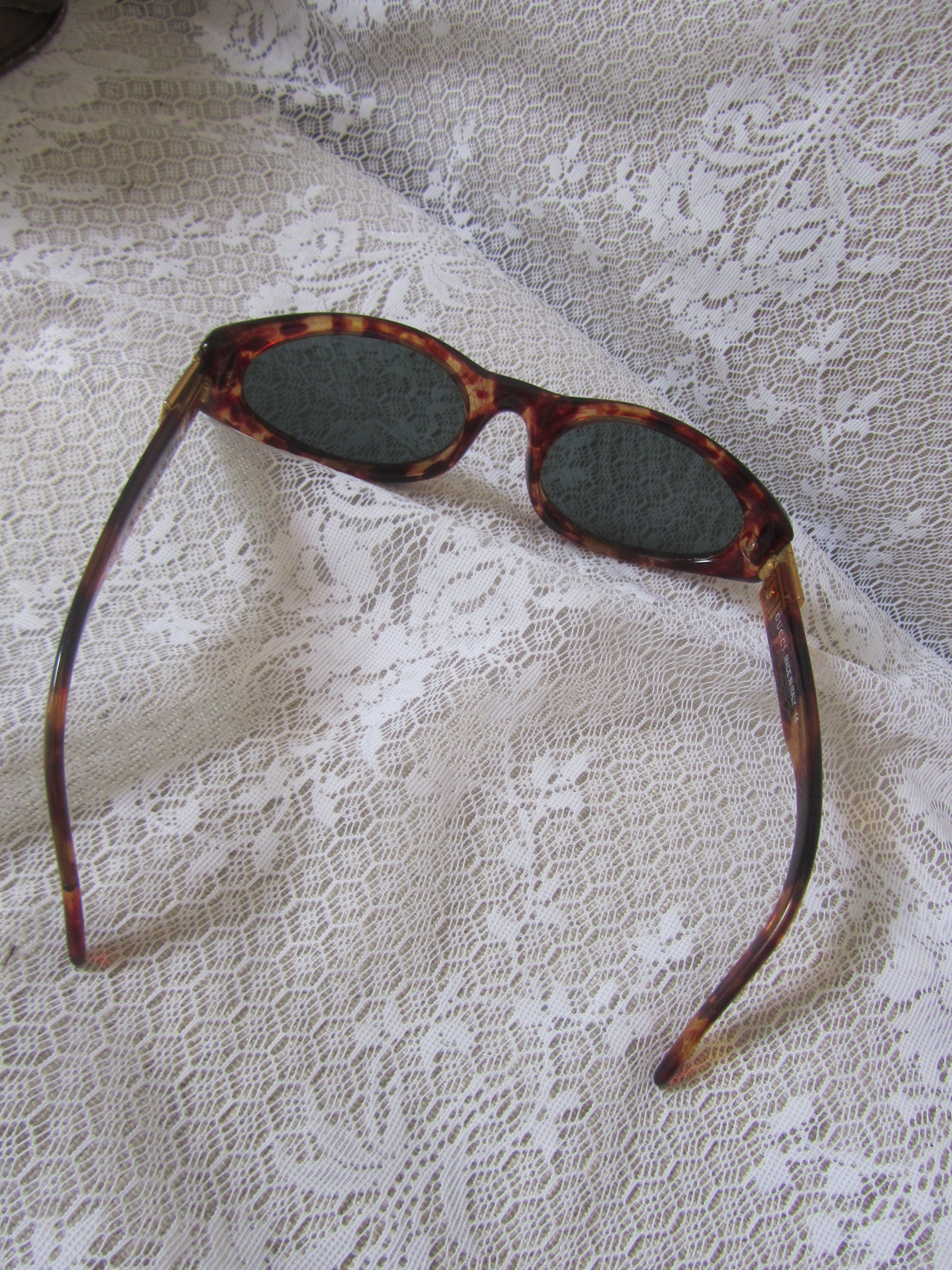 Sunglasses with tortoiseshell frame on a textured white fabric background