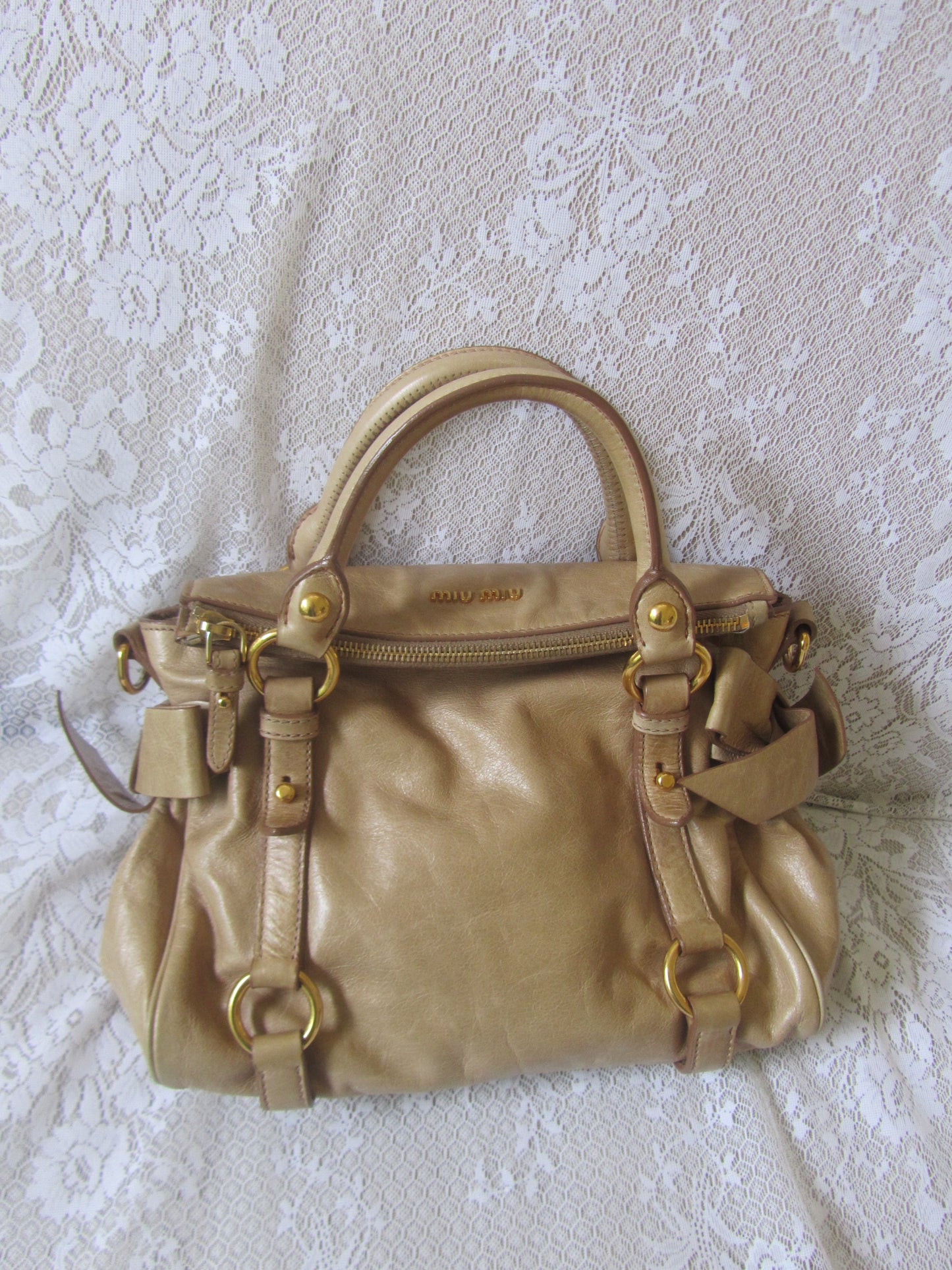 Gold handbag on a textured white surface
