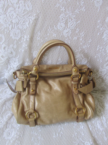 Gold handbag on a textured white surface