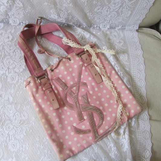 Pink polka dot bag with lace trim on a white lace tablecloth