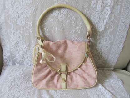 Pink handbag with beige accents on a lace background