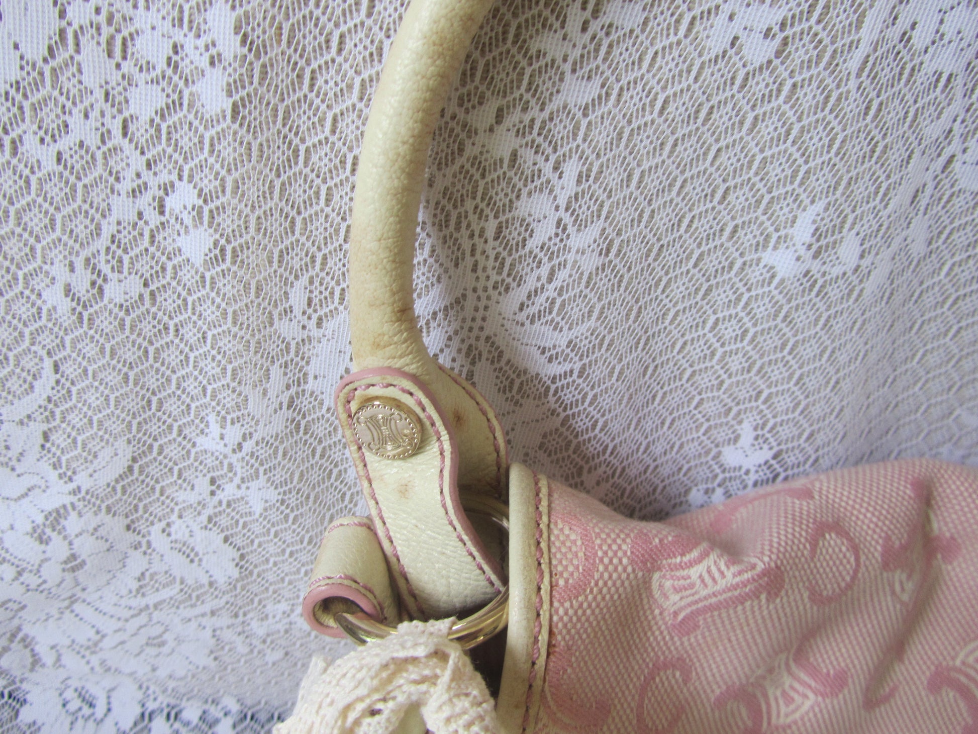 Cream-colored handbag with pink pattern on a lace background