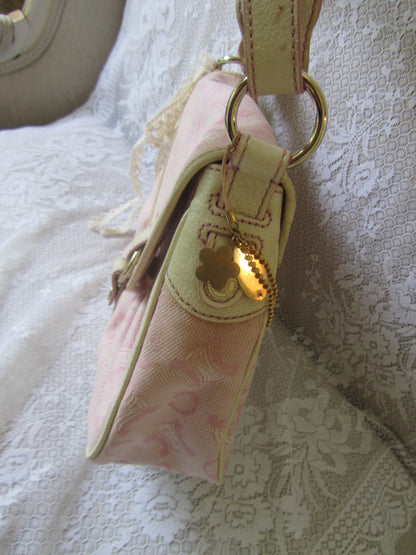 Pink pouch with gold accents on a textured white surface