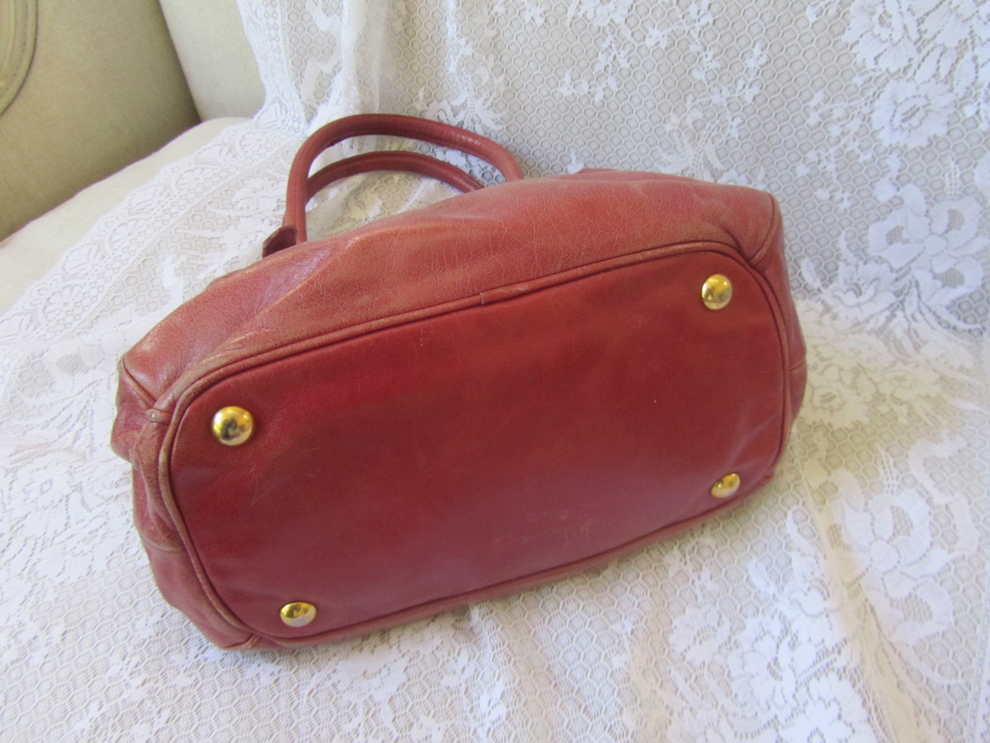 Red handbag with gold studs on a textured surface