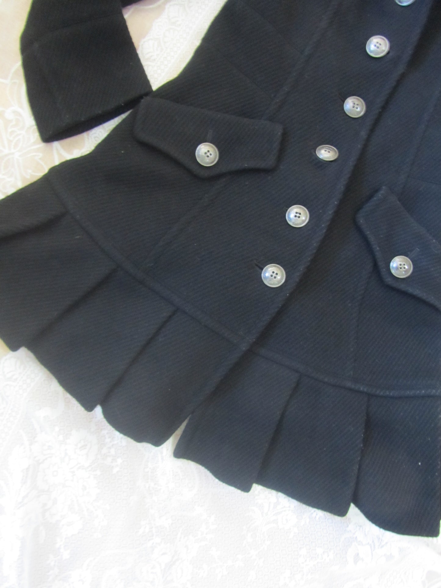 Close-up of a dark blue coat with buttons on a light background