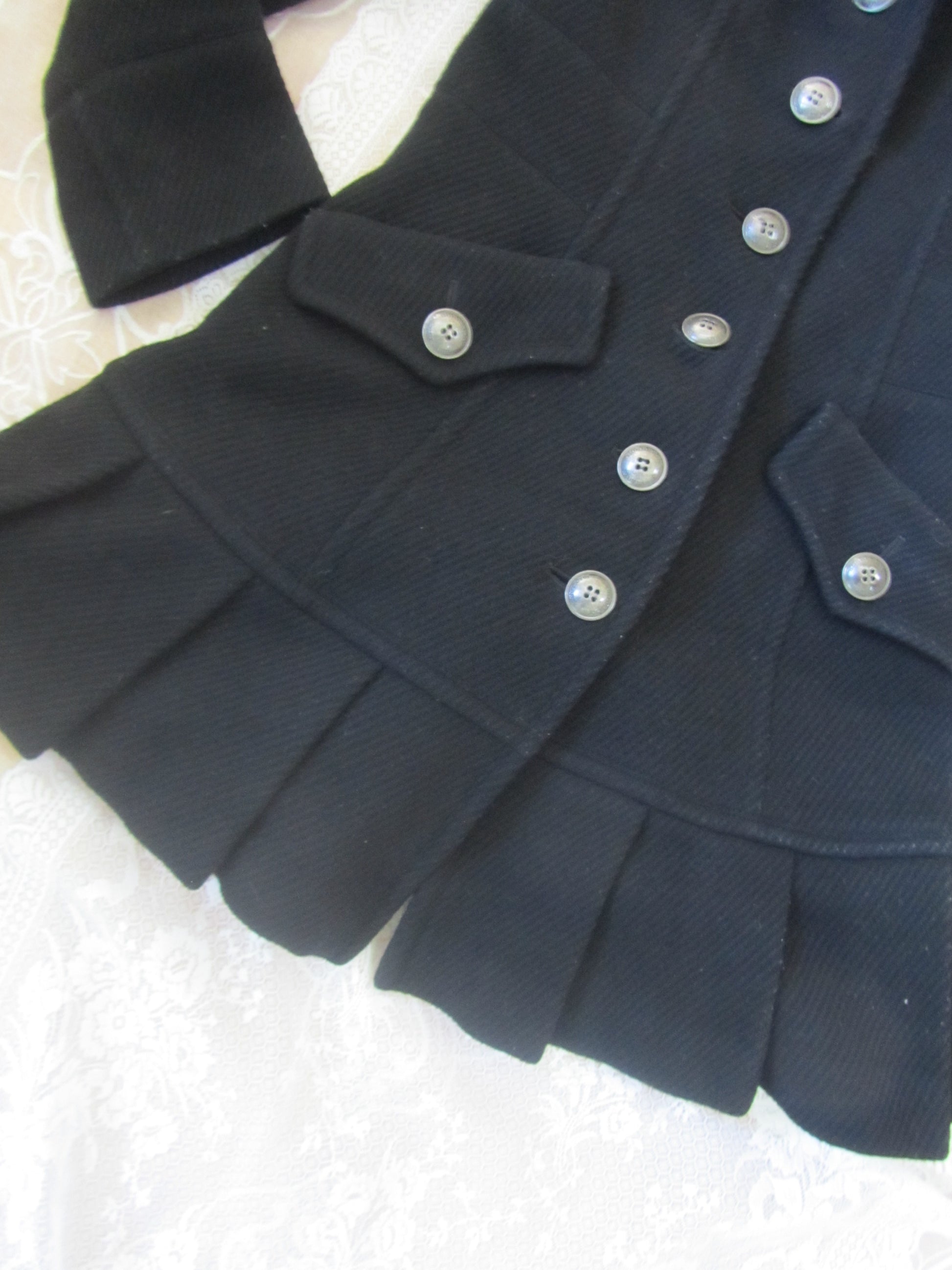 Close-up of a dark blue coat with buttons on a light background