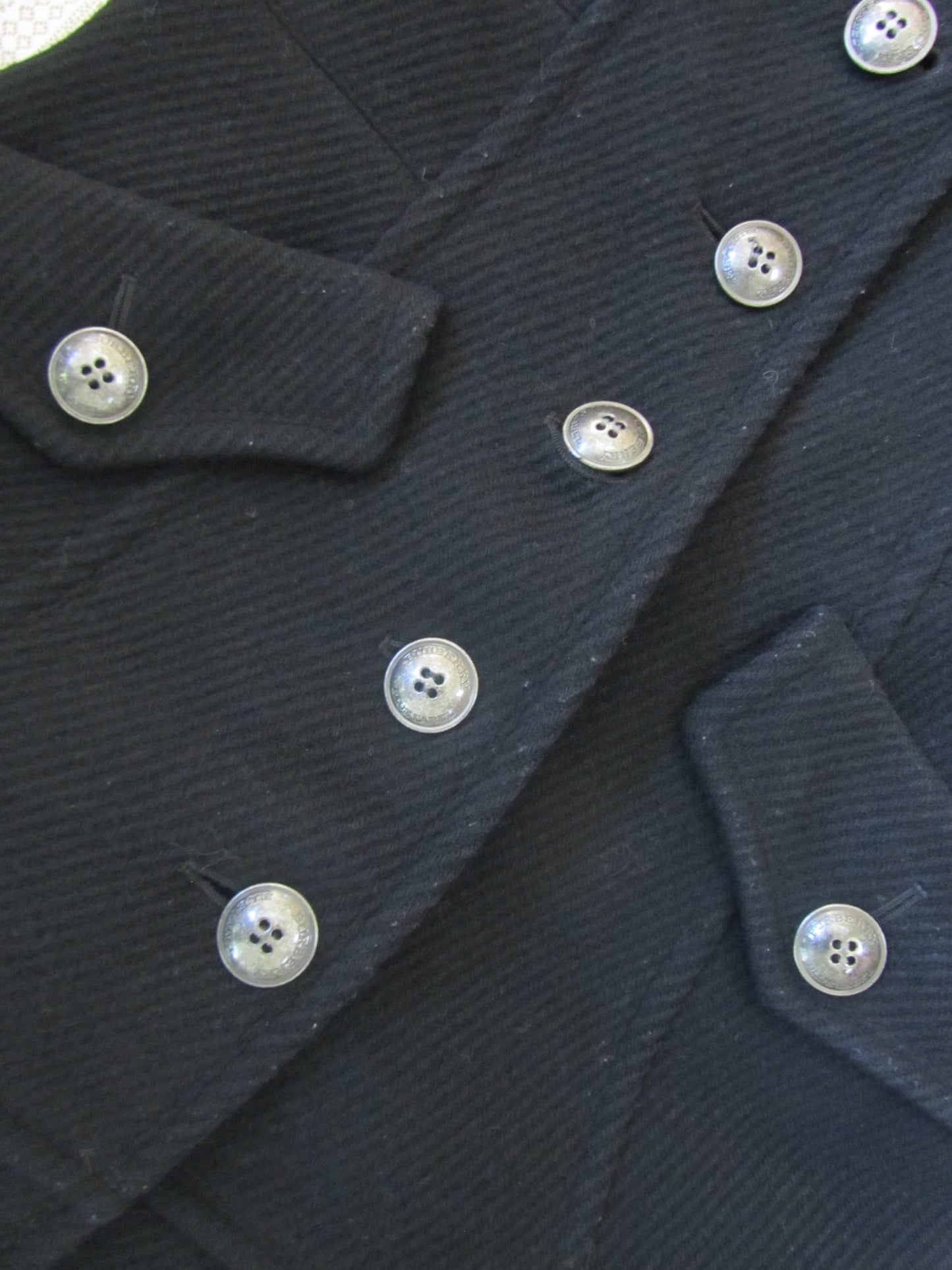 Close-up of a dark blue textured fabric with buttons