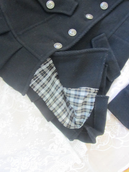Black coat with plaid lining on a white surface