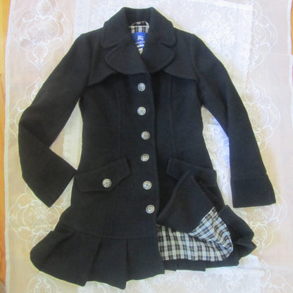Black coat with plaid lining on a white surface
