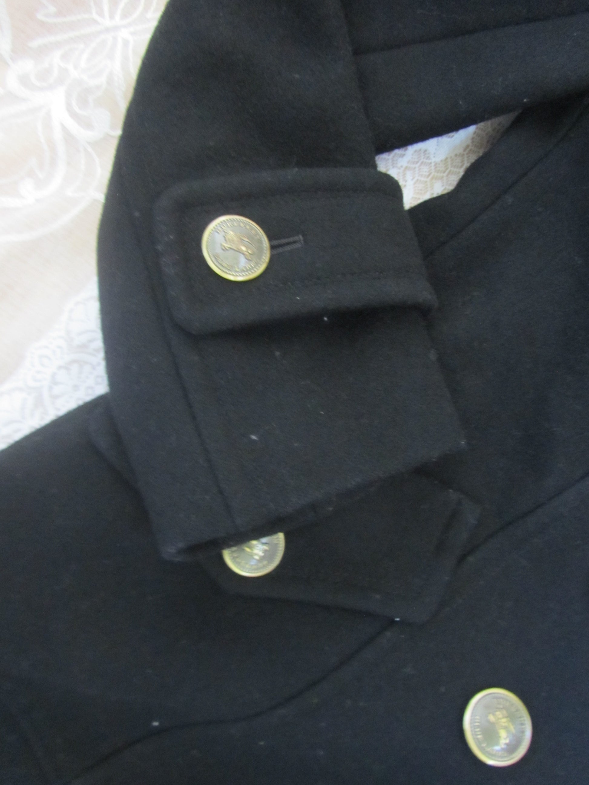 Close-up of a dark coat with buttons on a textured surface