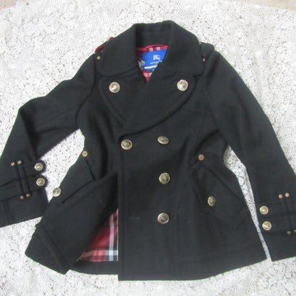 black peacoat with red plaid interior and golden buttons on a lace background