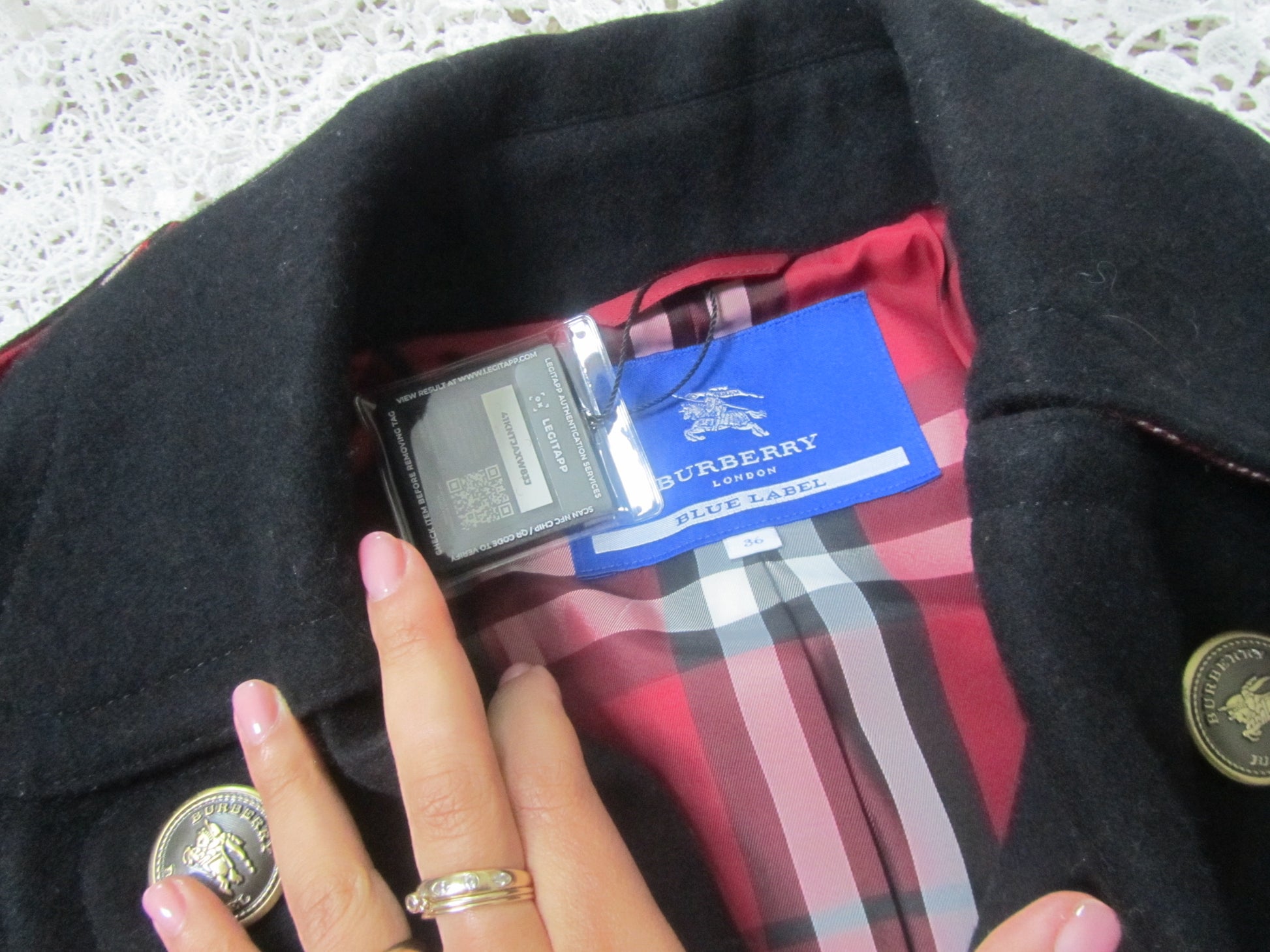 burberry london blue label tag on a black peacoat with red plaid interior