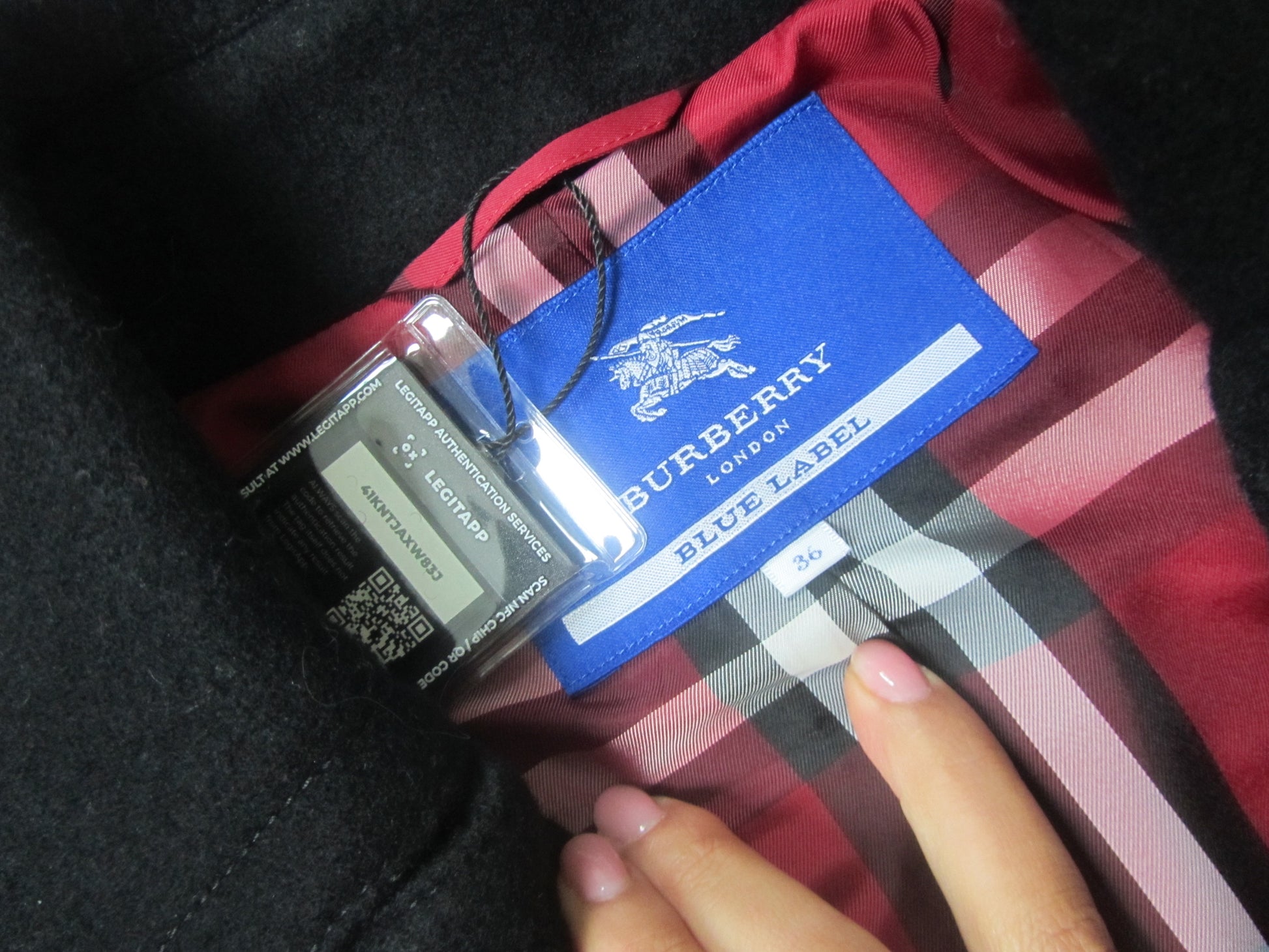 burberry london blue label tag on a black peacoat with red plaid interior