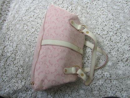 pink celine bag with cream handles and gold details on a lace background  