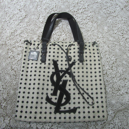 polkadot tote bag with YSL logo on a lace background 