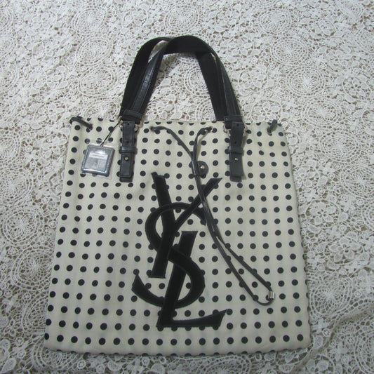polkadot tote bag with YSL logo on a lace background 