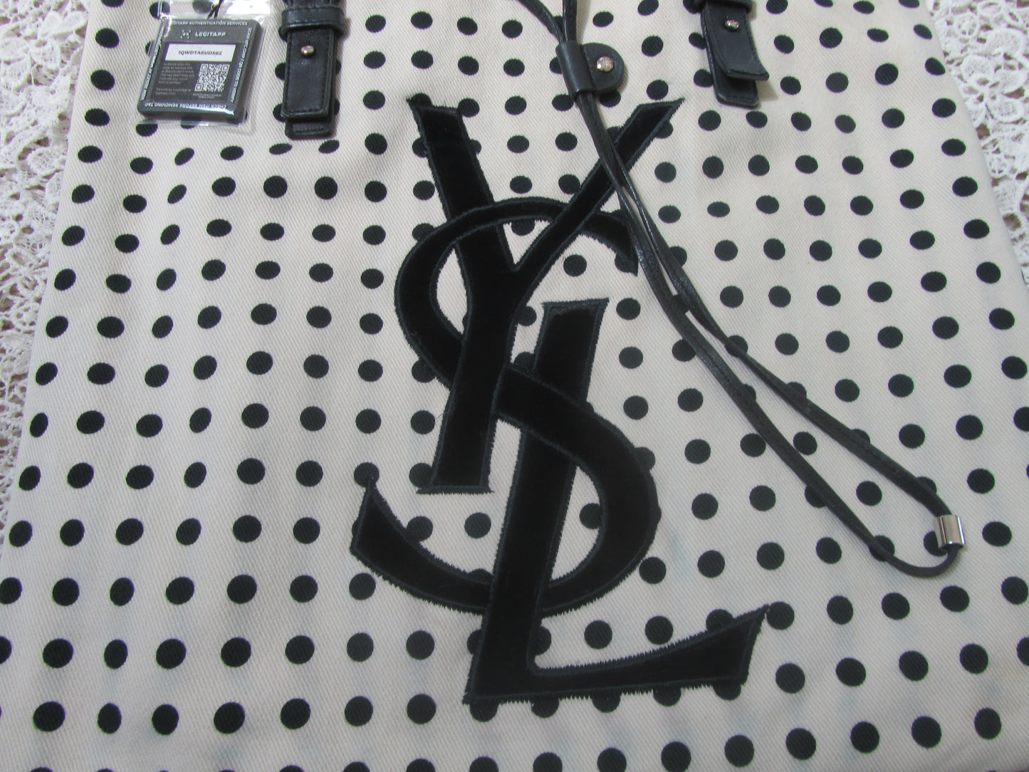 polkadot tote bag with YSL logo on a lace background 