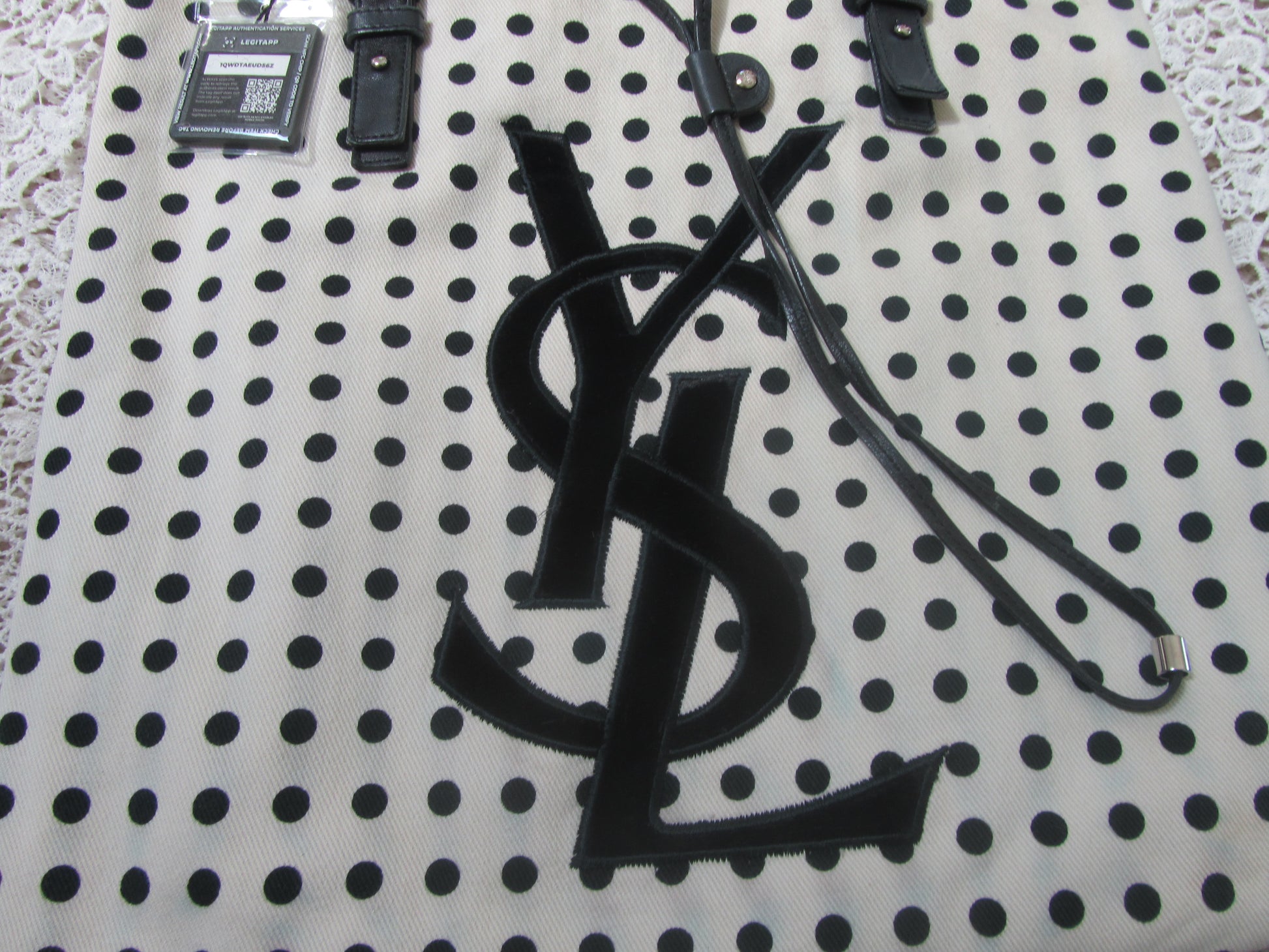 polkadot tote bag with YSL logo on a lace background 