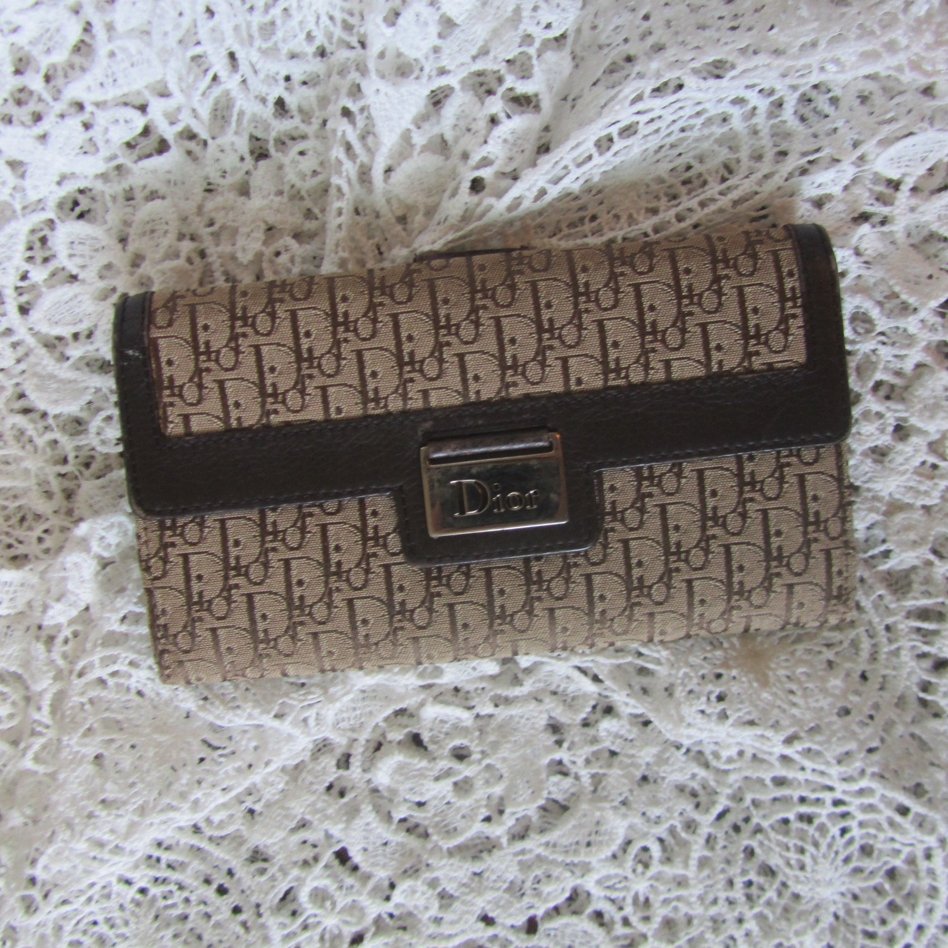 Designer wallet with brand logo on a lace background