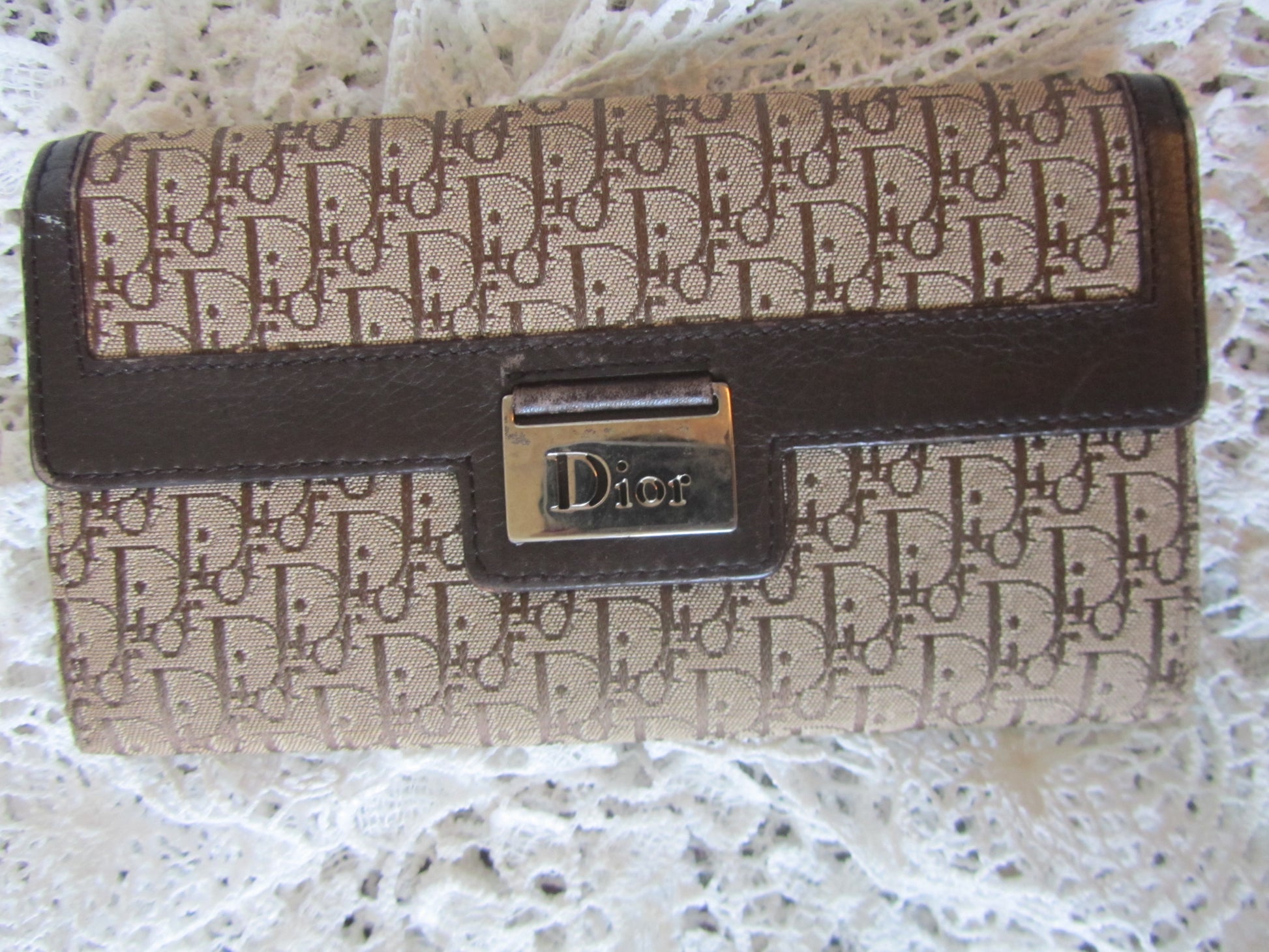 Designer handbag with visible brand logo on a textured surface