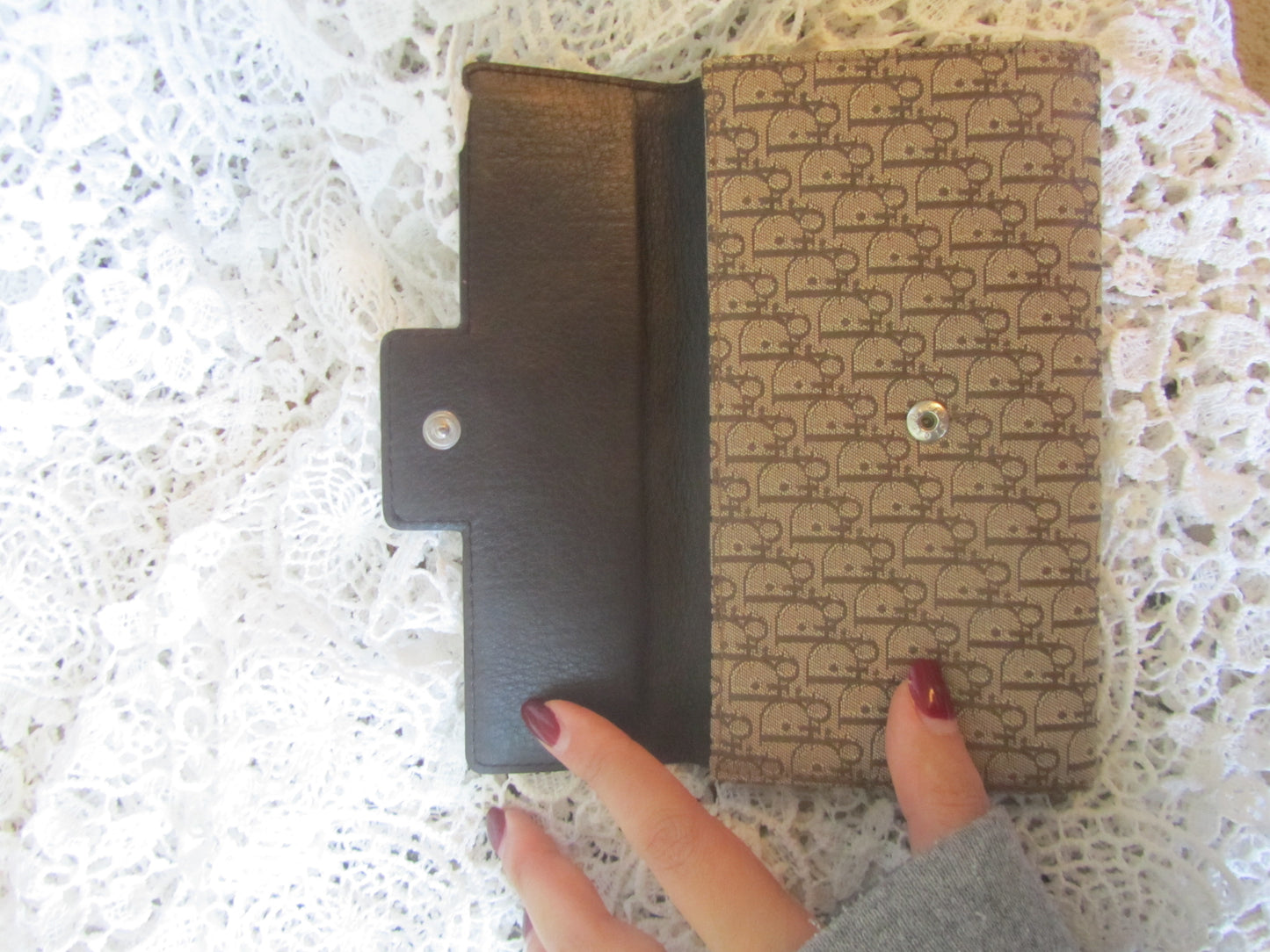 Patterned wallet held by a hand on a textured surface