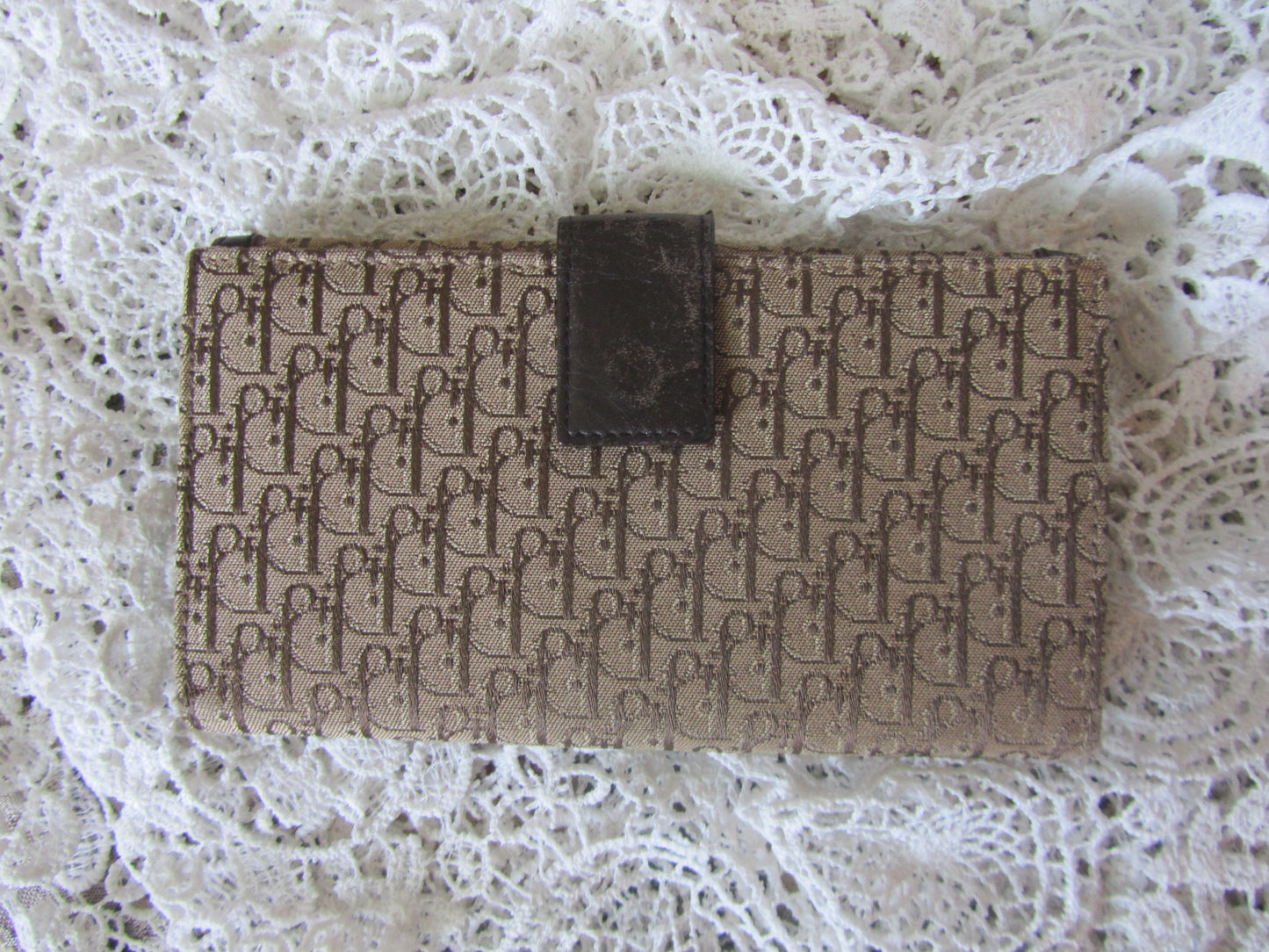Designer handbag with brand logo on a lace background