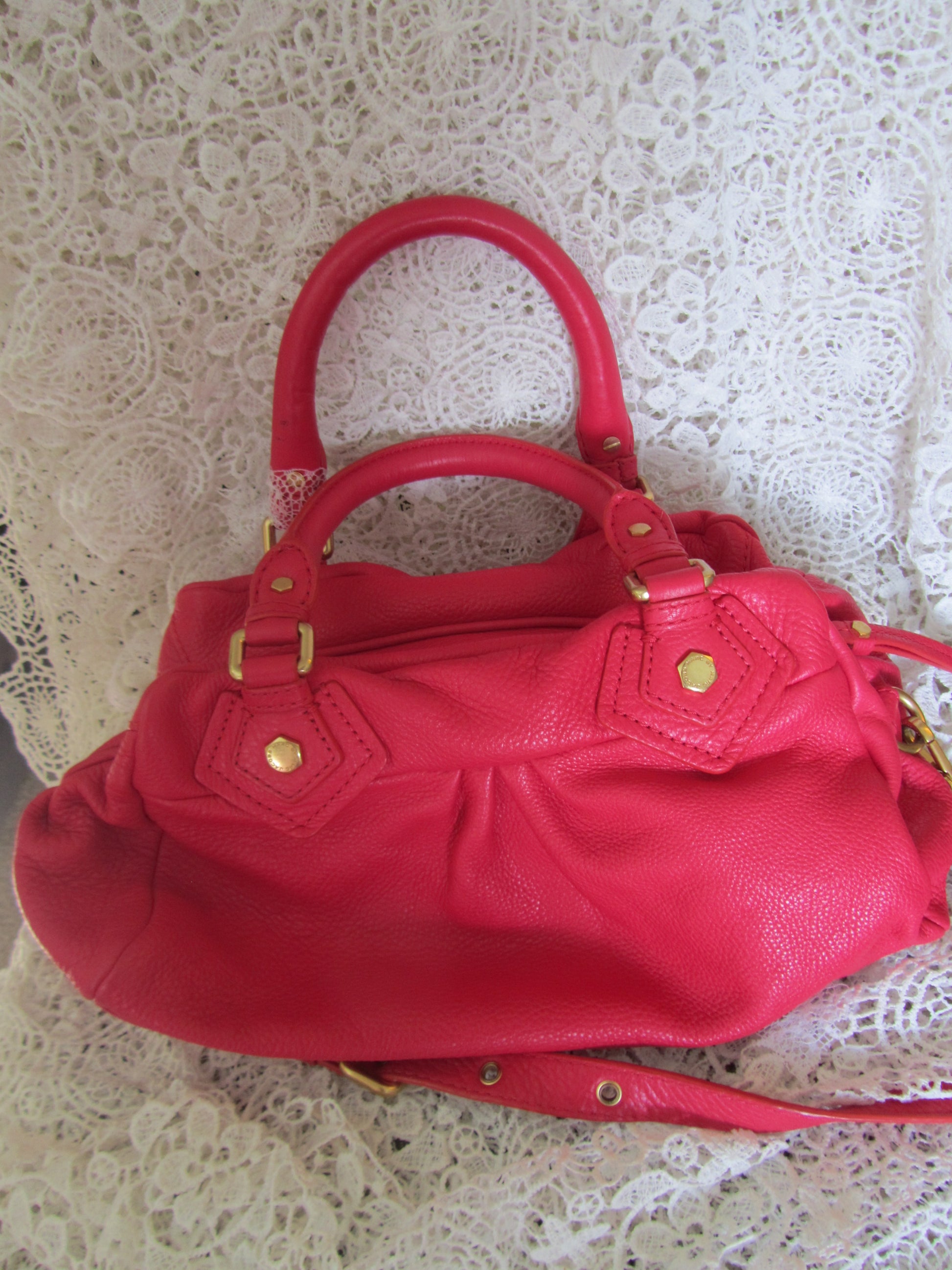Red handbag with gold accents on a lace background