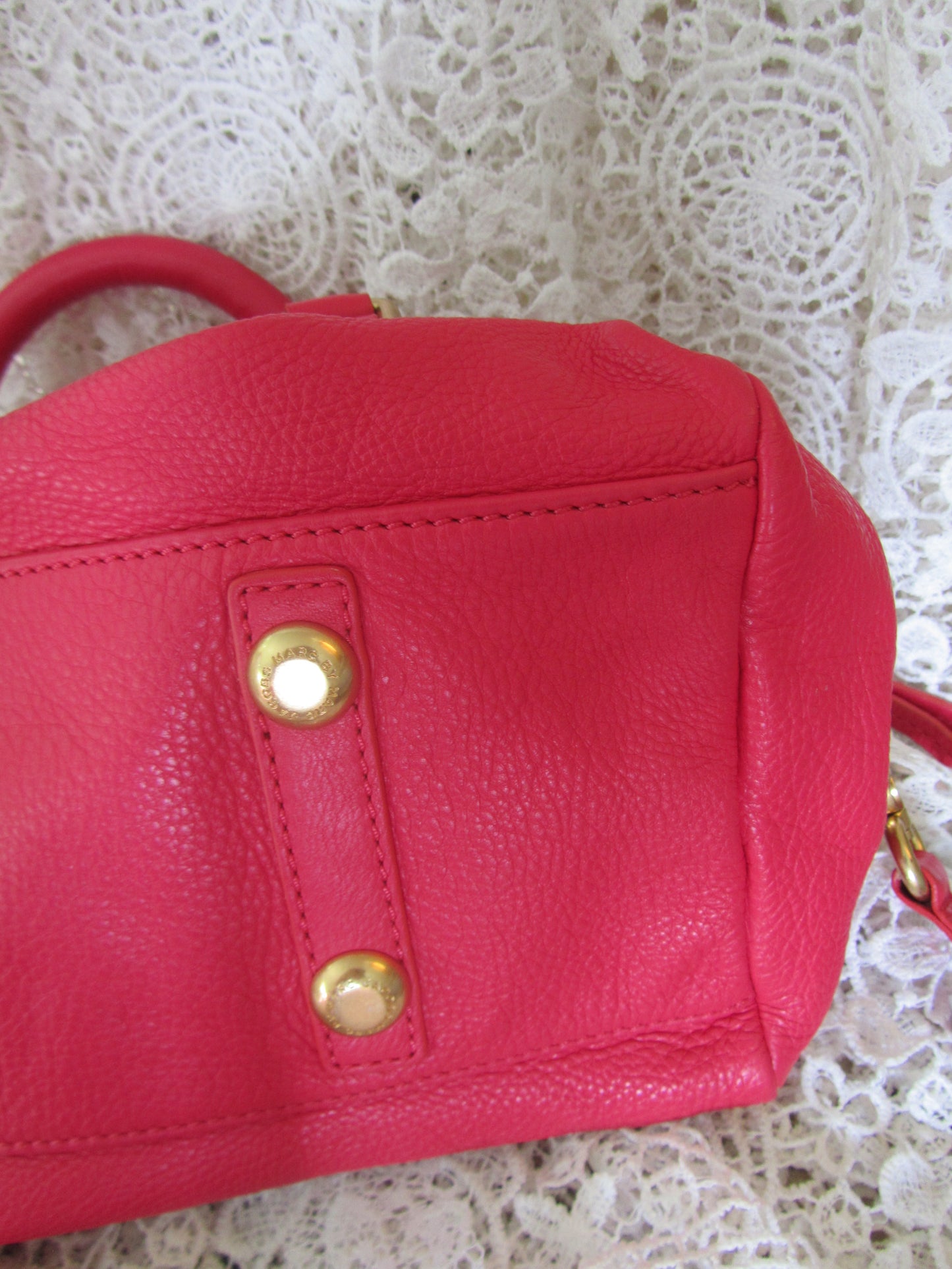Red handbag with gold accents on a lace background