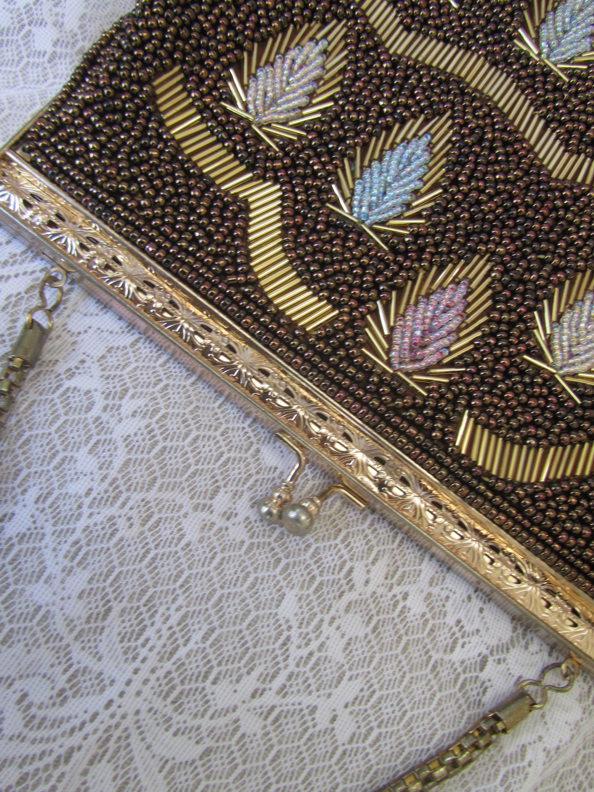 Close-up of an ornate beaded clutch bag on a lace background