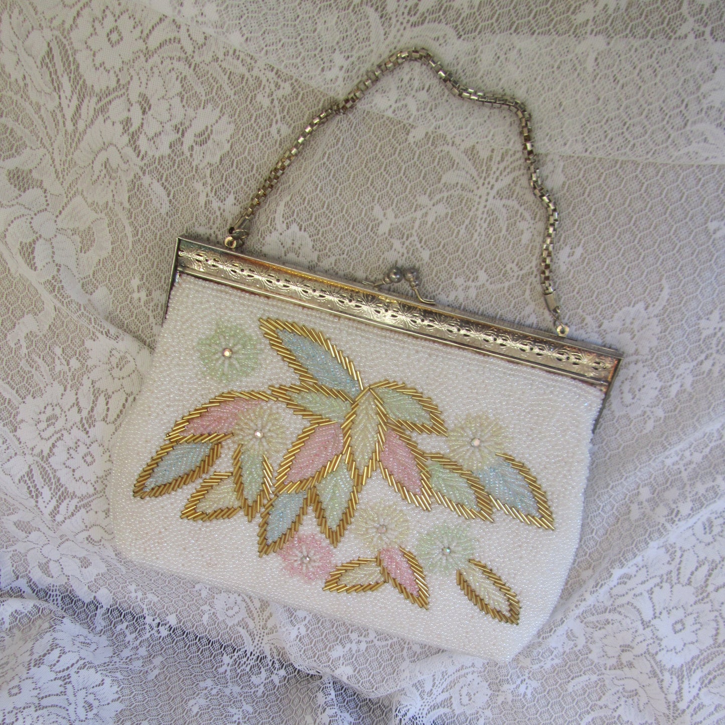 Embroidered clutch bag on a textured lace background