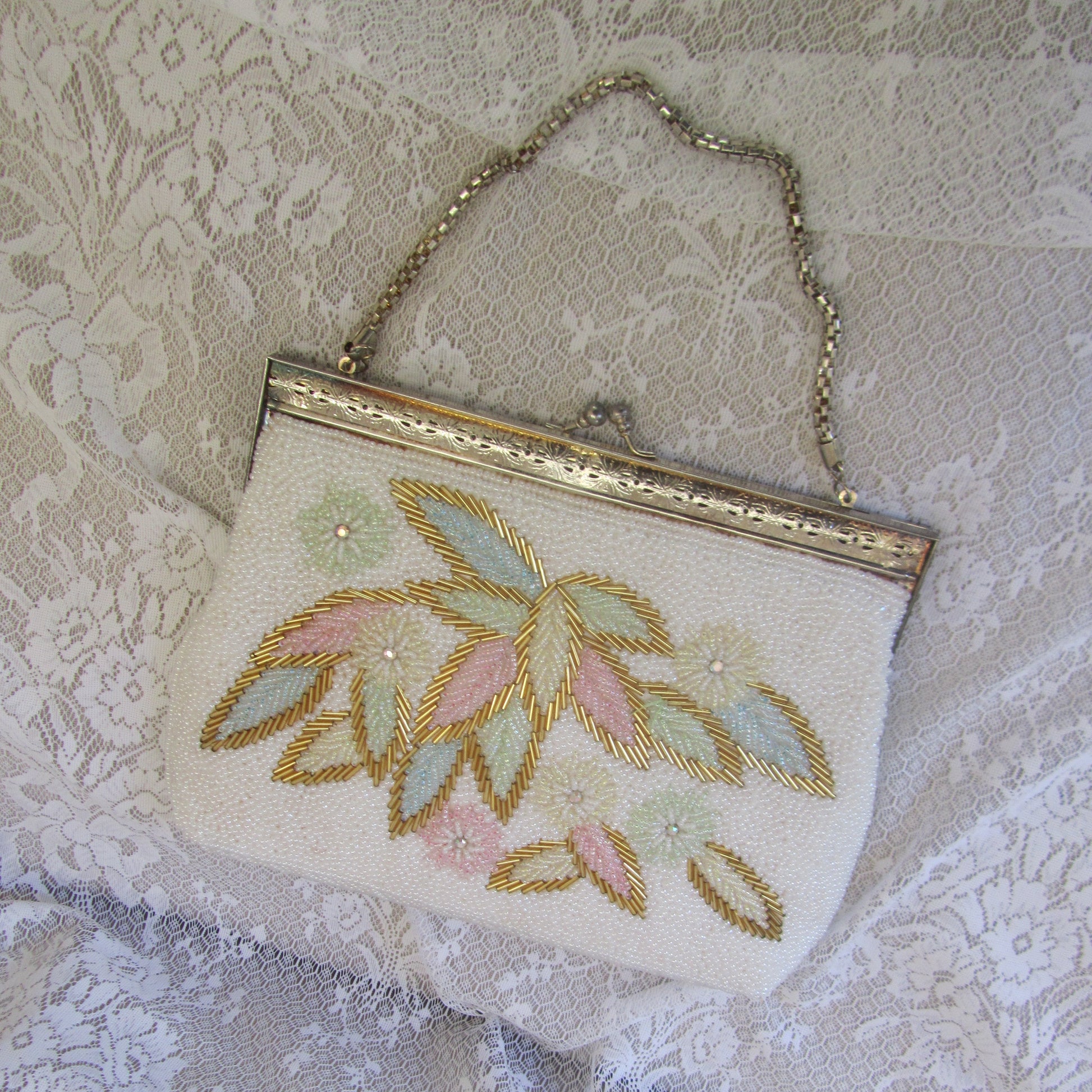 Embroidered clutch bag on a textured lace background
