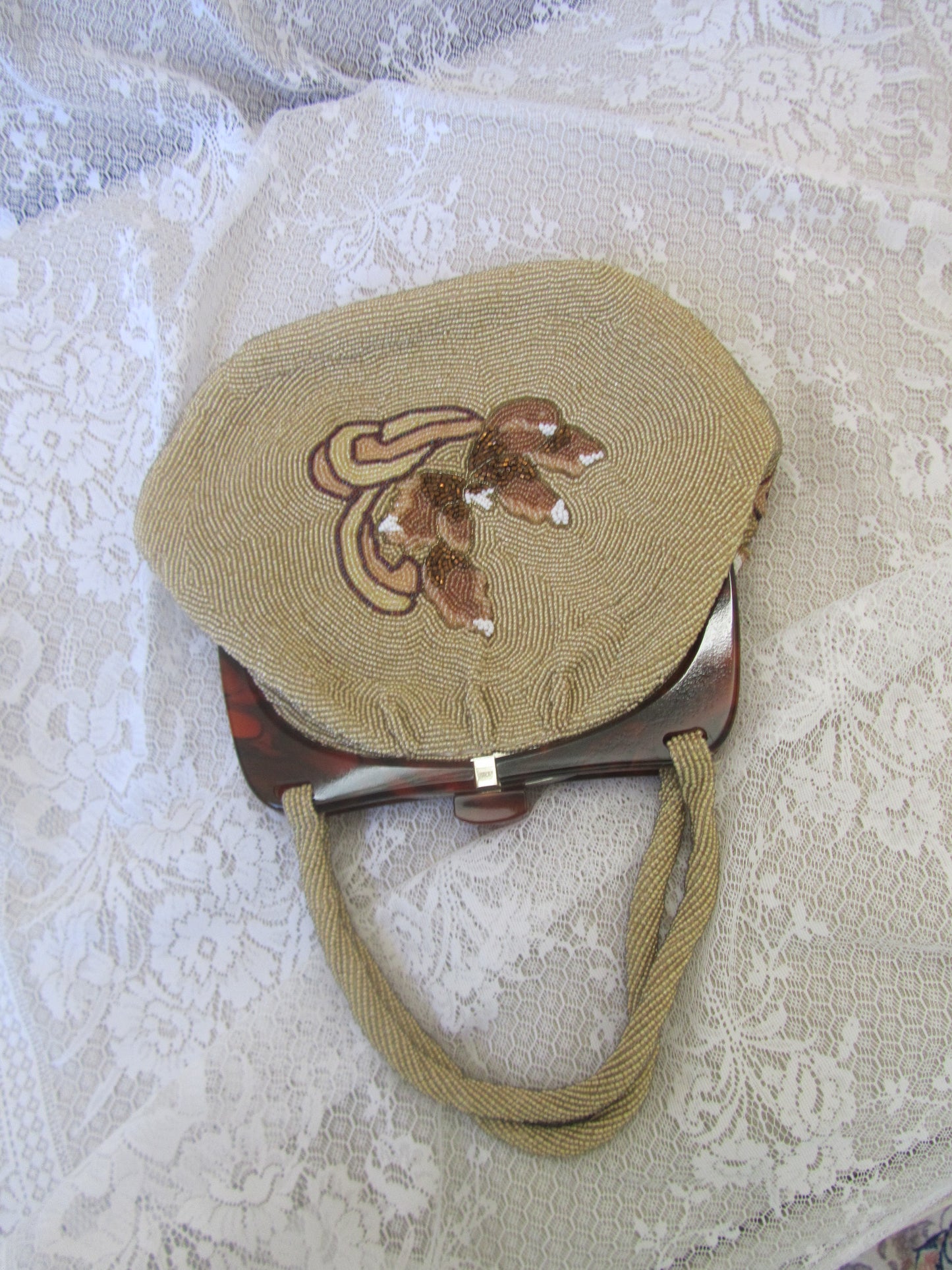 Round embroidered bag with a handle on a textured white background