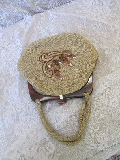 Round embroidered bag with a handle on a textured white background