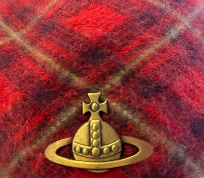 Gold emblem on a red and brown plaid fabric