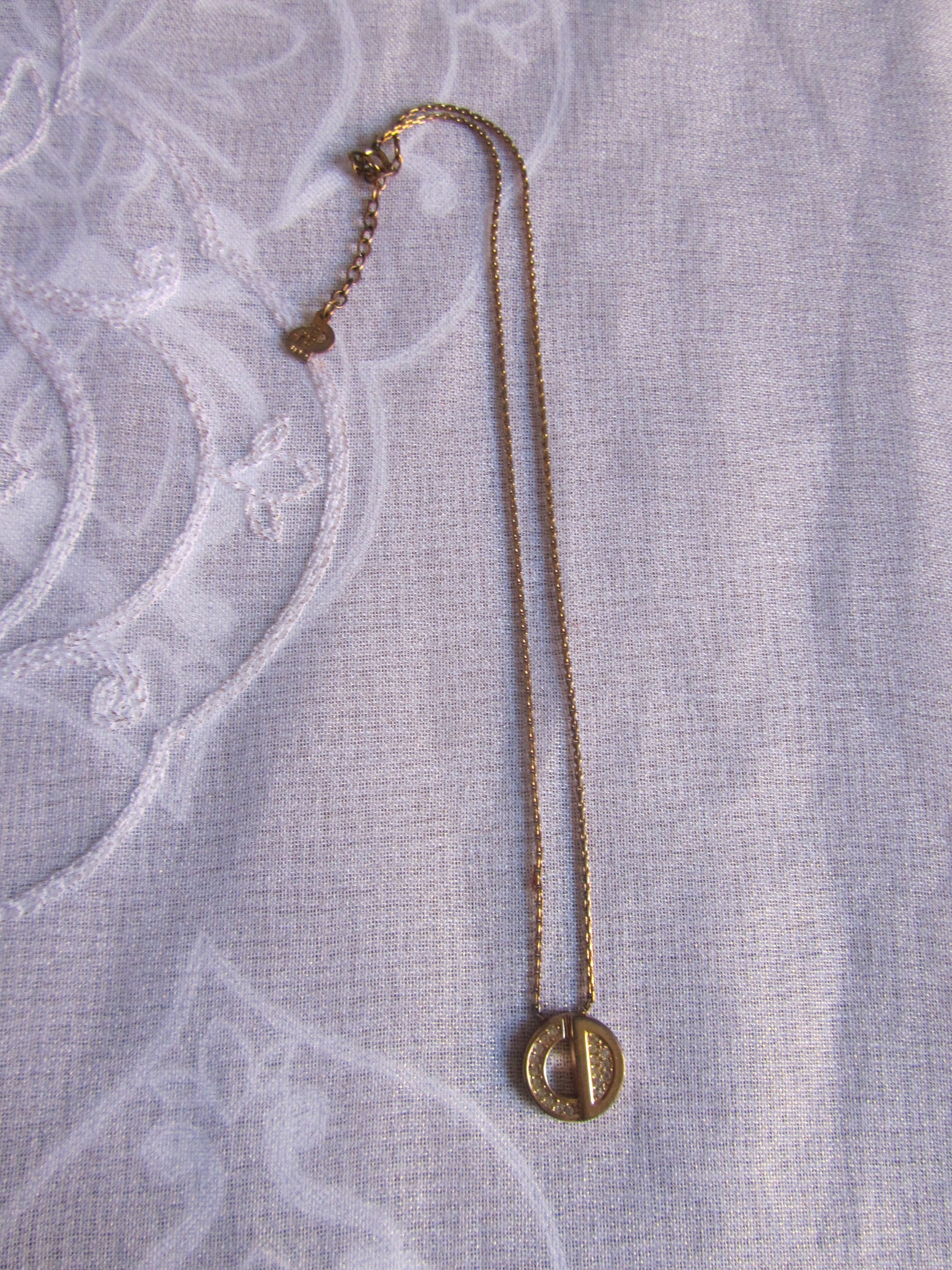 Gold necklace on a textured light gray fabric background