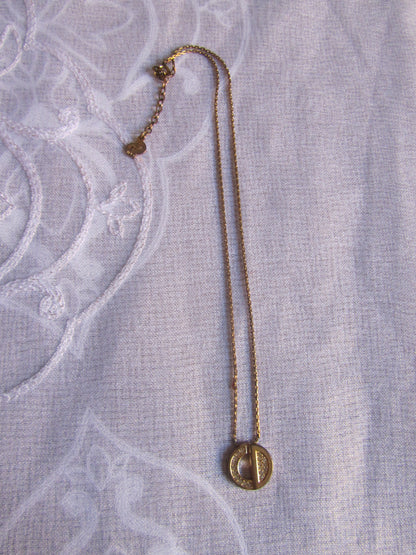 Gold necklace on a textured light gray fabric background