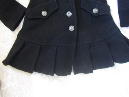 Black coat with plaid lining on a white surface