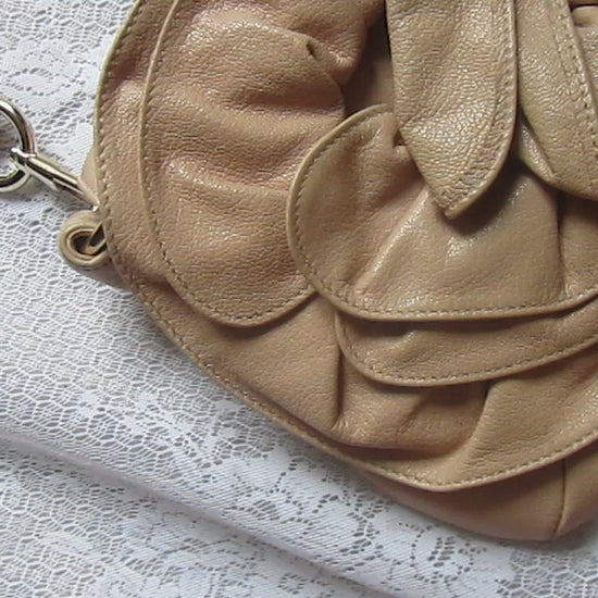 Beige handbag with floral design on a textured surface