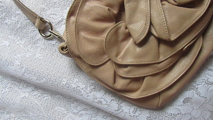 Beige handbag with floral design on a textured surface