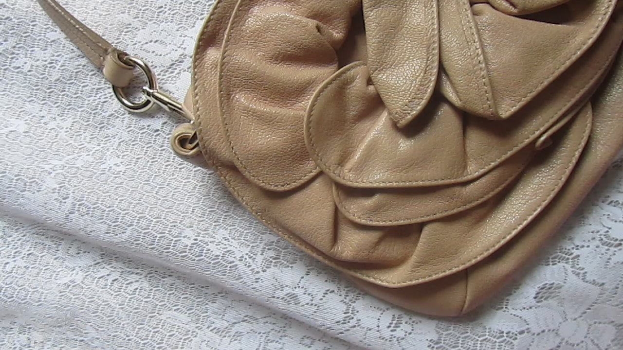 Beige handbag with floral design on a textured surface