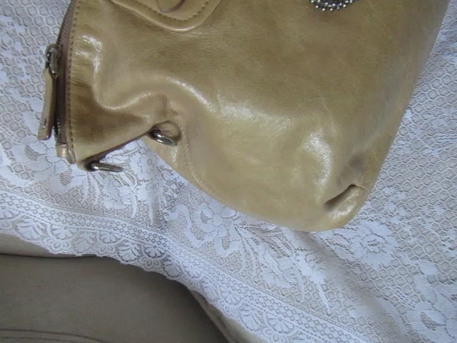 handbag with heart charm detailing on a textured white surface