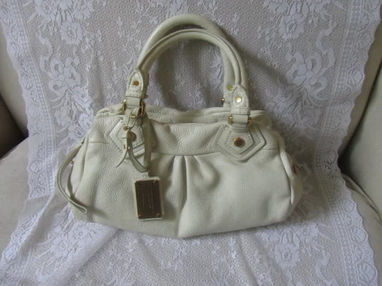 White handbag on a textured white surface
