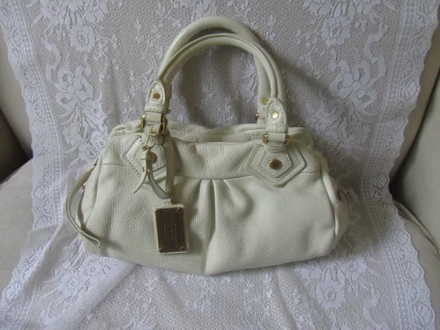White handbag on a textured white surface