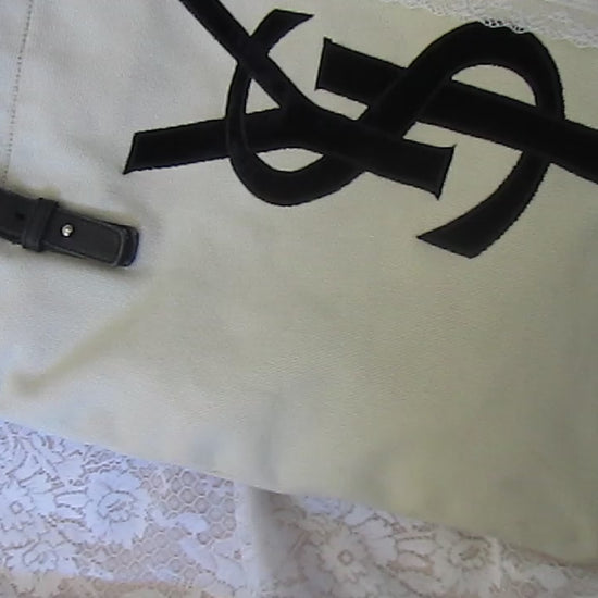 Beige tote bag with black straps on a textured white background