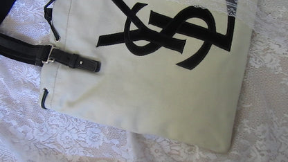 Beige tote bag with black straps on a textured white background