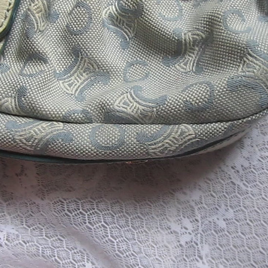 Light blue handbag with lace details on a textured white background