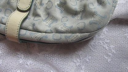 Light blue handbag with lace details on a textured white background